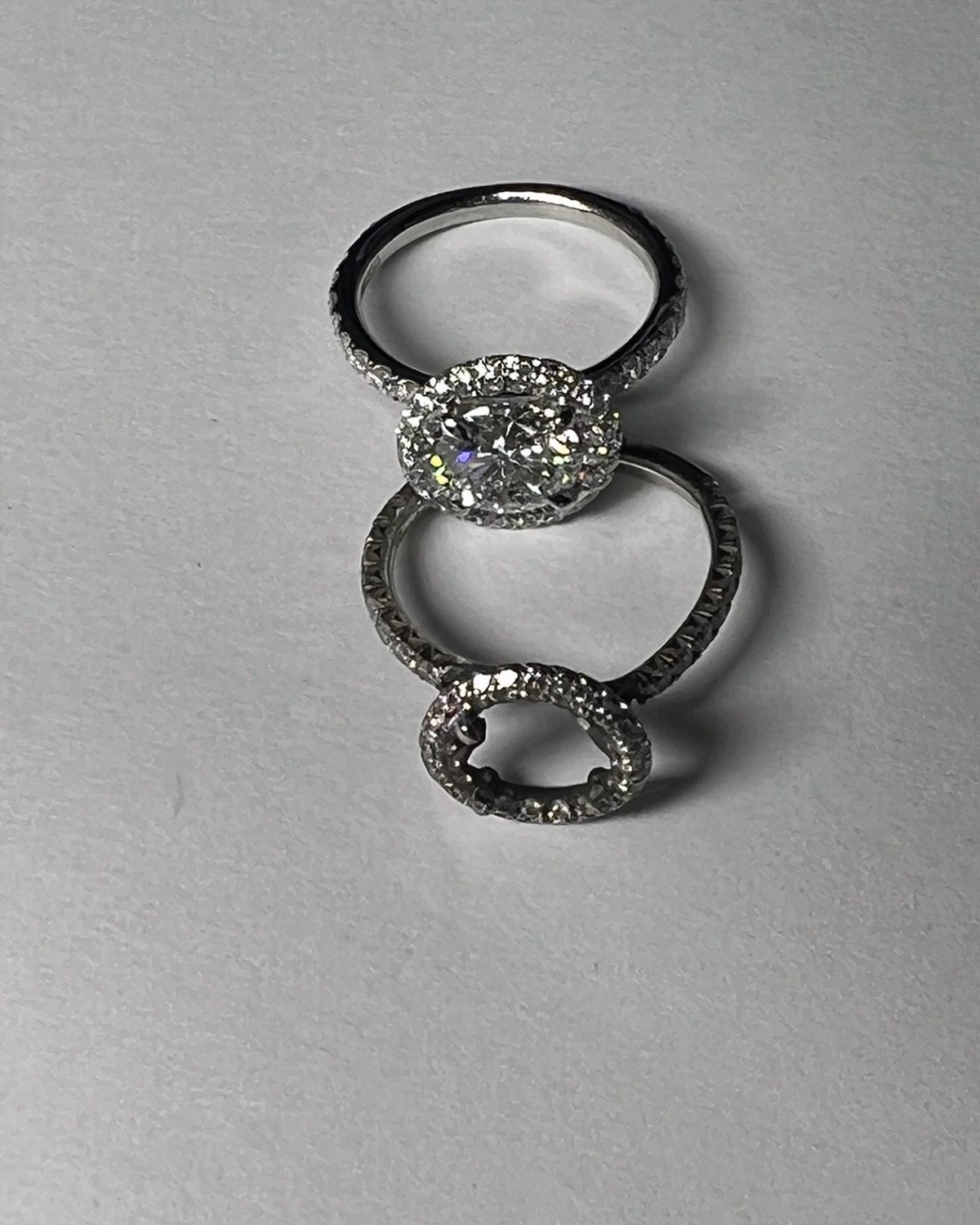 Matched bridal set — a round diamond halo engagement ring and its contoured open-halo wedding band, photographed together
