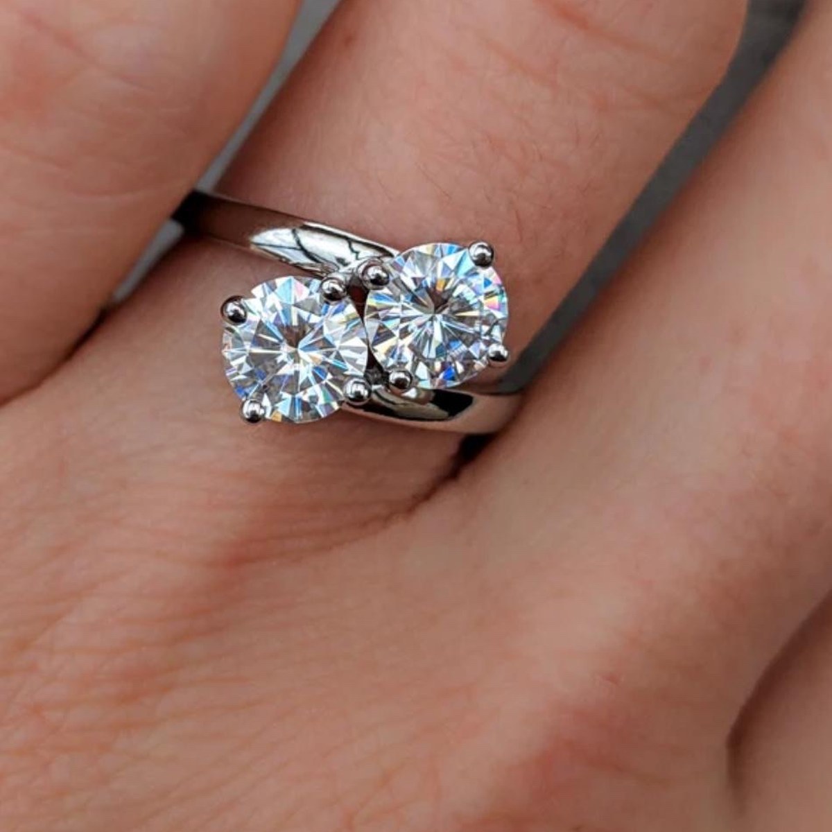 Toi et moi two-stone diamond ring — two round brilliants on a bypass band in white gold, worn on the hand